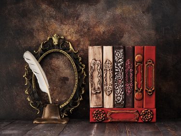 Vintage books on a shelf, a bronze frame and old inkwell